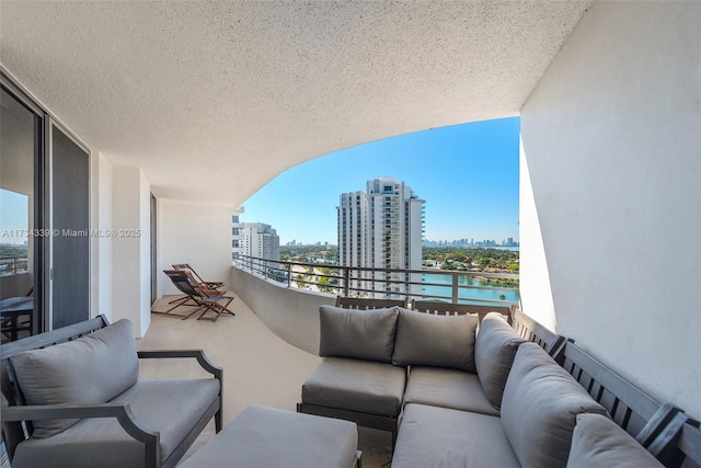 balcony featuring an outdoor living space and a water view