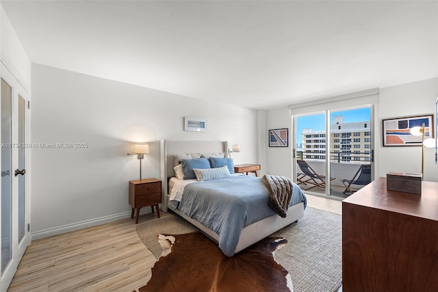 bedroom featuring access to exterior and light hardwood / wood-style floors