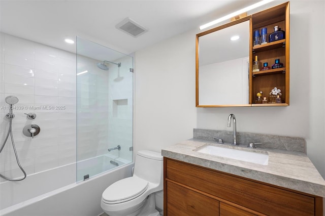 full bathroom with tiled shower / bath, vanity, and toilet