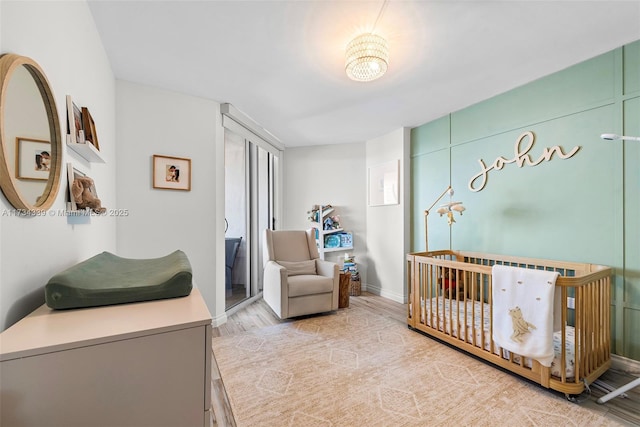 bedroom featuring a crib and light hardwood / wood-style flooring