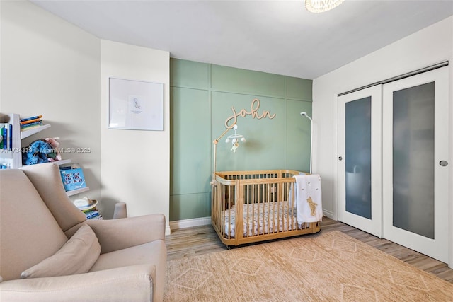 bedroom with hardwood / wood-style floors and a crib