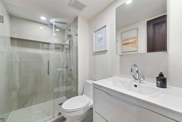 bathroom with vanity, an enclosed shower, and toilet