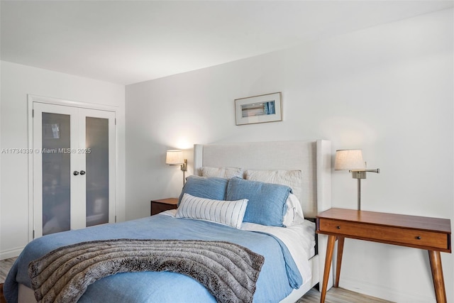 bedroom with french doors and light wood-type flooring