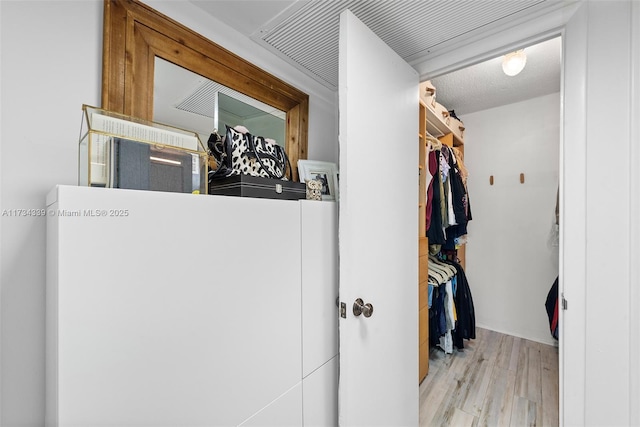 hallway featuring light hardwood / wood-style flooring and a textured ceiling