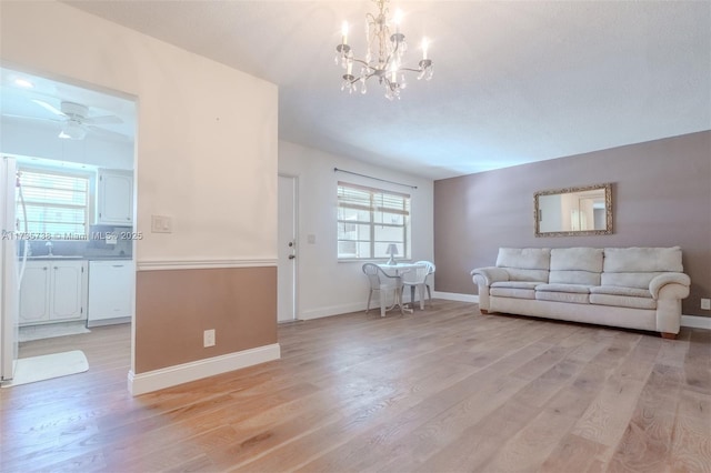 580 Egret Dr Unit 119, Hallandale Beach, FL 33009 - living room featuring baseboards, ceiling fan with notable chandelier, and light wood-style floors