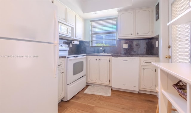 580 Egret Dr Unit 119, Hallandale Beach, FL 33009 - kitchen featuring backsplash, a sink, white cabinets, white appliances, and light wood-style flooring
