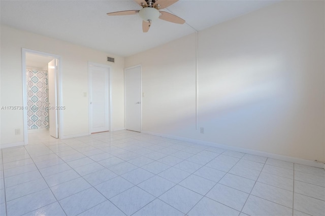 spare room with ceiling fan and light tile patterned floors