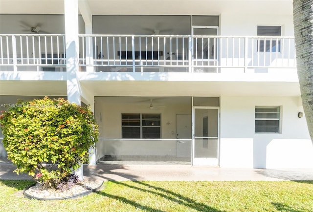 rear view of property with ceiling fan and a balcony