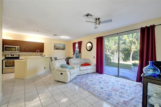 tiled living room with a healthy amount of sunlight, a textured ceiling, and ceiling fan