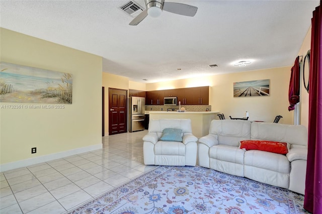 tiled living room featuring a textured ceiling and ceiling fan