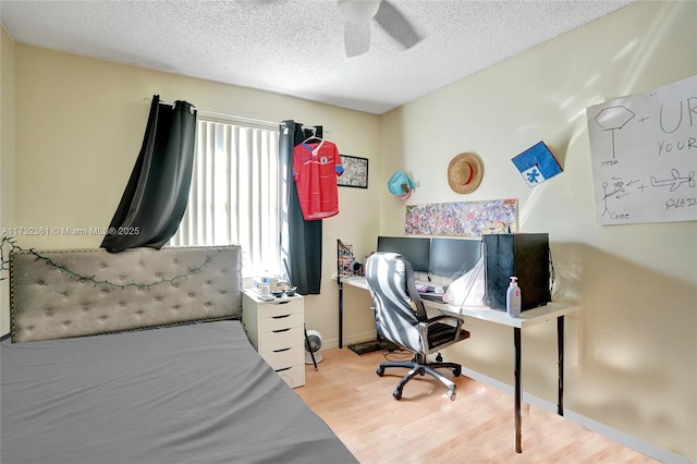 bedroom with ceiling fan, a textured ceiling, and light wood-type flooring