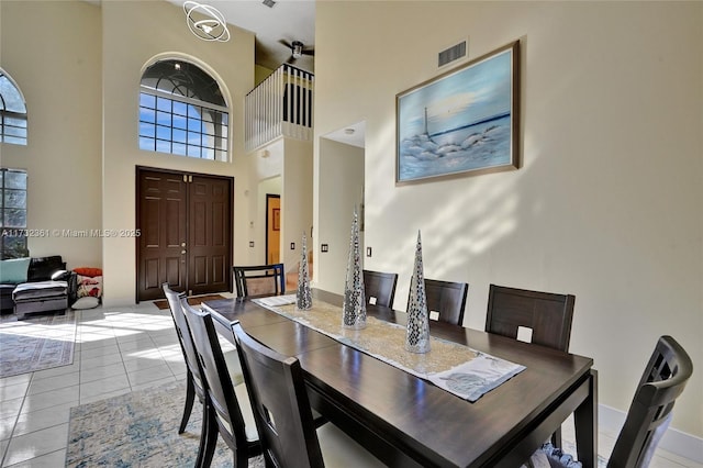 dining room featuring a towering ceiling and tile patterned floors