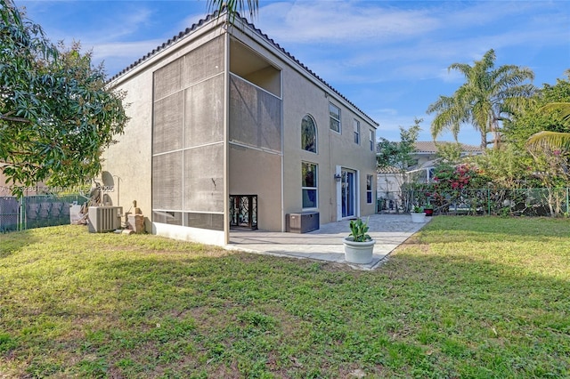 back of house featuring central AC, a patio, and a lawn