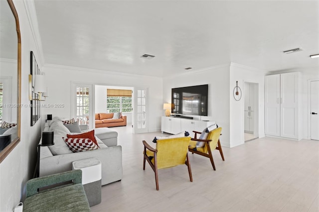 living room with crown molding and light hardwood / wood-style floors