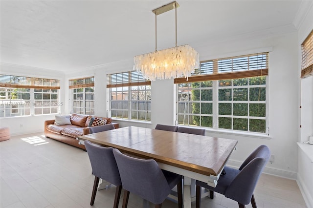 dining room featuring crown molding, a healthy amount of sunlight, and an inviting chandelier