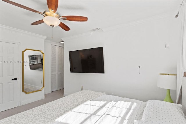 bedroom featuring a closet, ornamental molding, light hardwood / wood-style floors, and ceiling fan