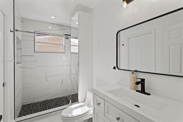 bathroom featuring vanity, toilet, and tiled shower