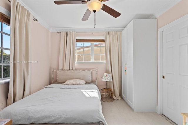 bedroom featuring crown molding, light carpet, and ceiling fan