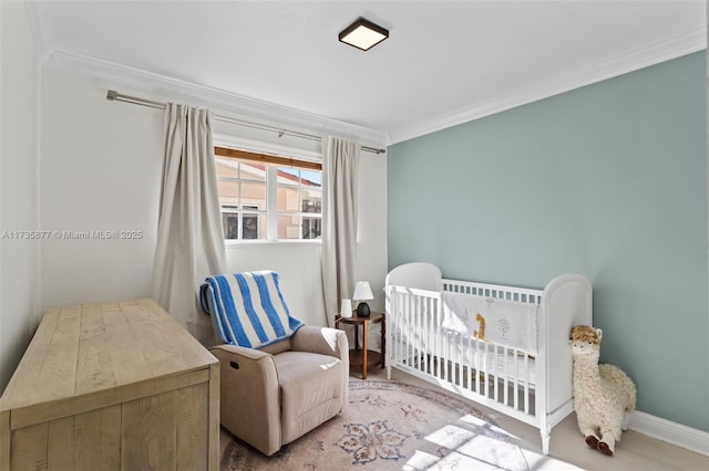 bedroom featuring ornamental molding, light hardwood / wood-style floors, and a crib