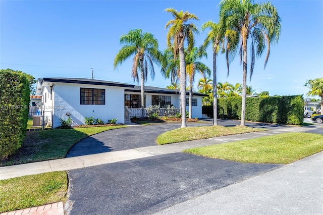 single story home with a front yard, central air condition unit, and covered porch