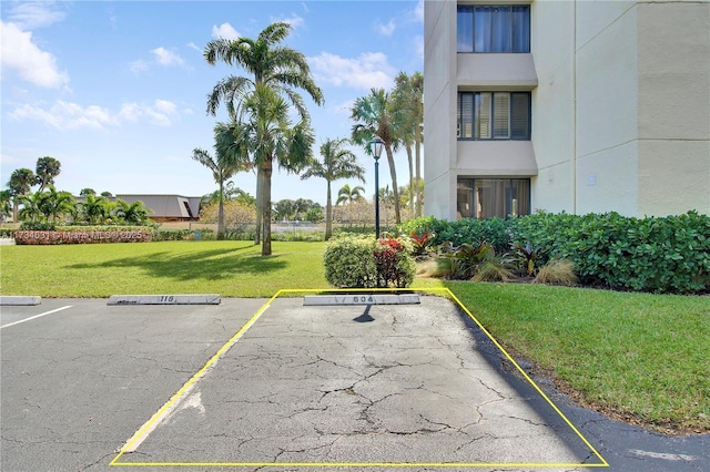 view of parking / parking lot featuring a yard