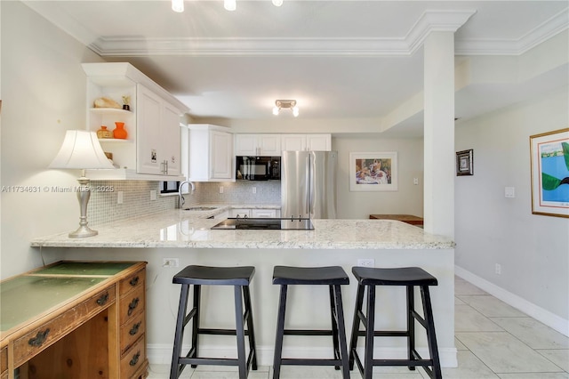 kitchen featuring a breakfast bar, sink, black appliances, kitchen peninsula, and white cabinets