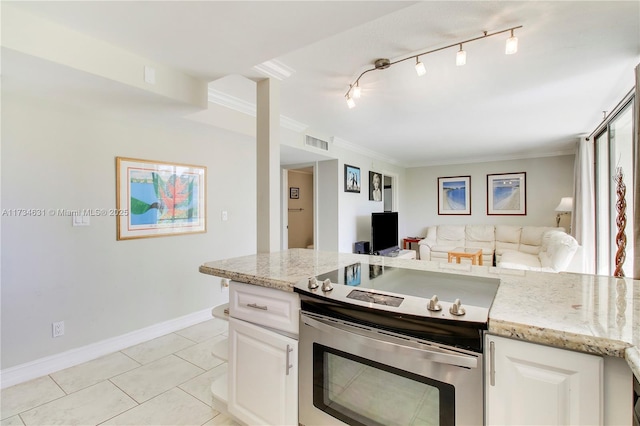 kitchen with light tile patterned floors, white cabinetry, track lighting, light stone countertops, and stainless steel electric stove