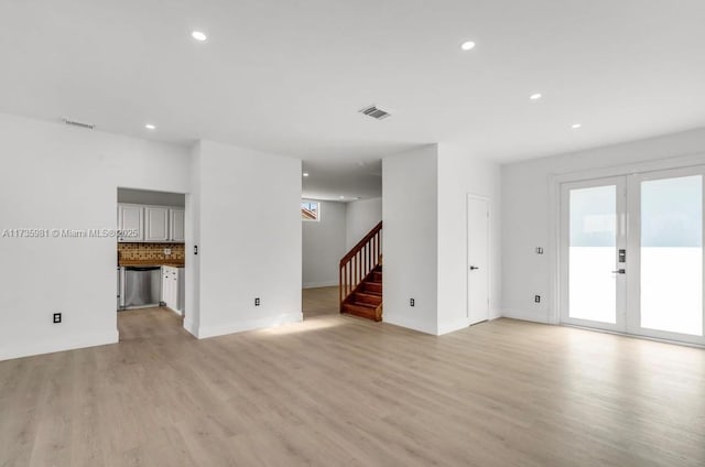 unfurnished living room featuring light hardwood / wood-style flooring and french doors