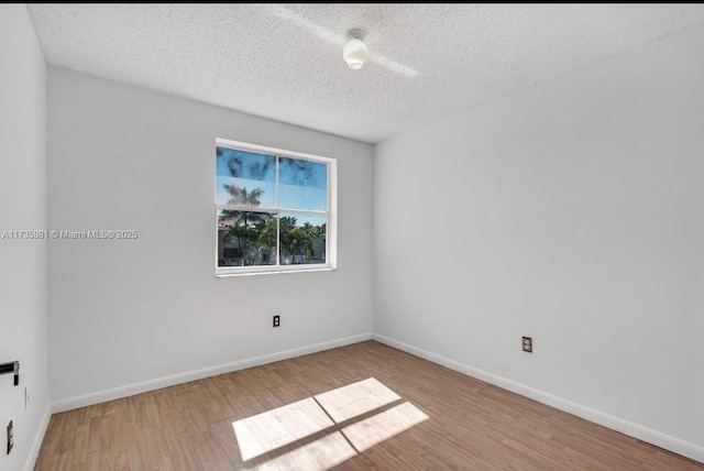 unfurnished room featuring light hardwood / wood-style flooring and a textured ceiling