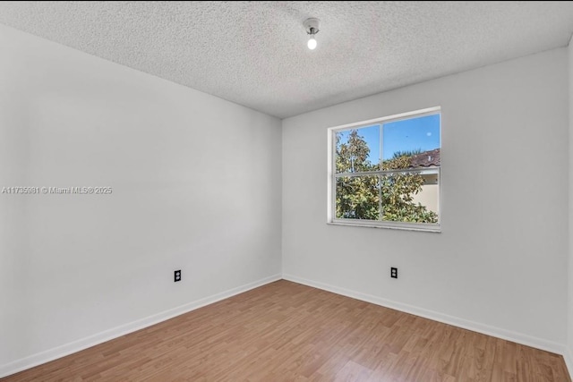 spare room with wood-type flooring and a textured ceiling