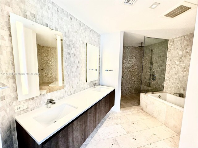 bathroom with tile walls, vanity, tasteful backsplash, and plus walk in shower