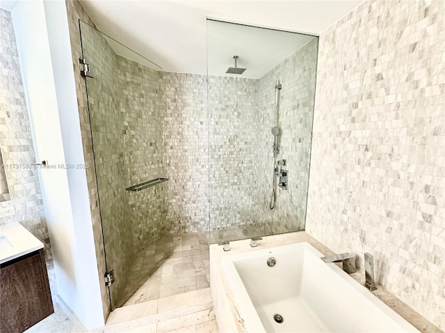 bathroom featuring tile walls, vanity, and plus walk in shower