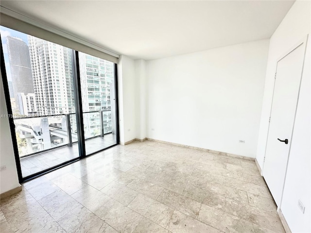 unfurnished room featuring a wall of windows