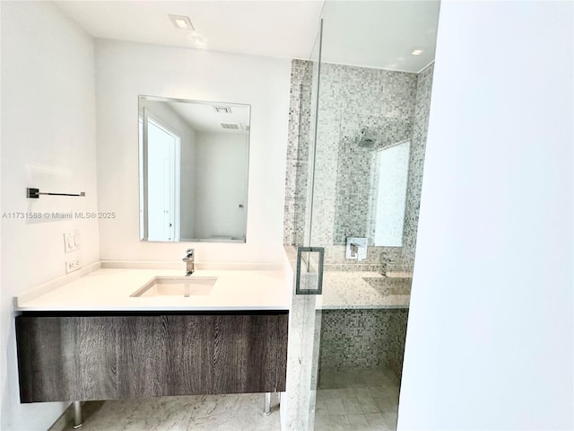 bathroom featuring a shower with door and vanity