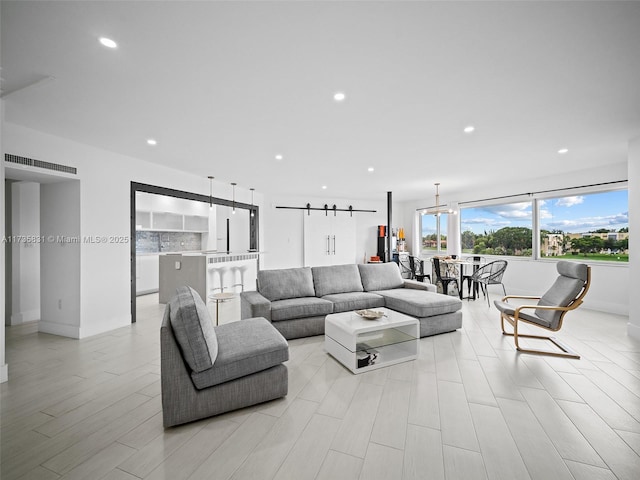 living room featuring a barn door and light hardwood / wood-style floors