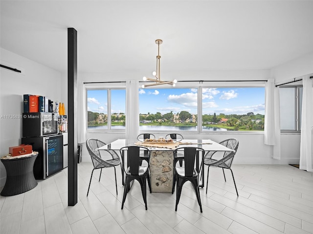 dining space featuring a chandelier and a water view