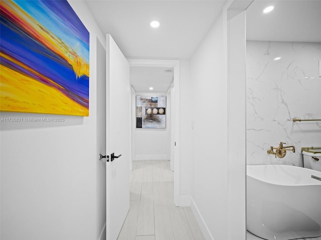 interior space featuring a washtub and tile walls