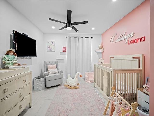 bedroom with a crib and ceiling fan