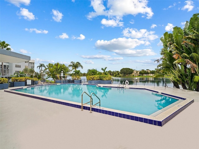 view of swimming pool featuring a patio and a water view