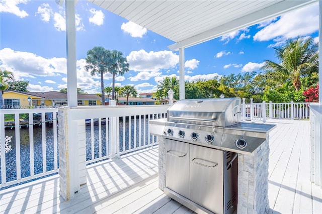 wooden deck with a water view and area for grilling