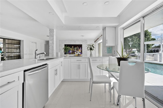 kitchen with white cabinetry, sink, kitchen peninsula, and dishwasher