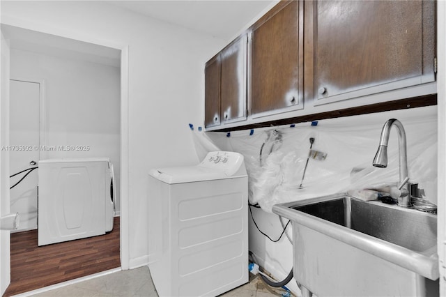 laundry area featuring sink, washer / dryer, cabinets, and light tile patterned floors