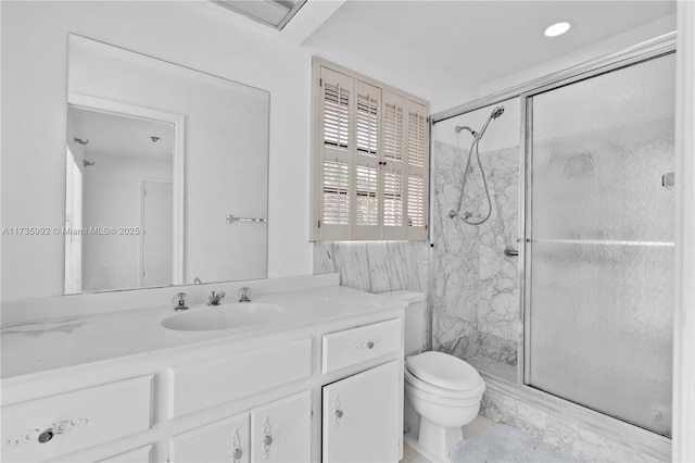 bathroom with a shower with door, vanity, and toilet