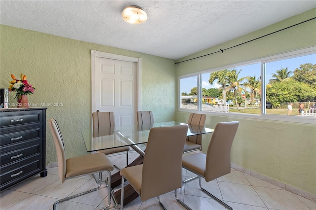 dining area featuring a textured ceiling and light tile patterned floors