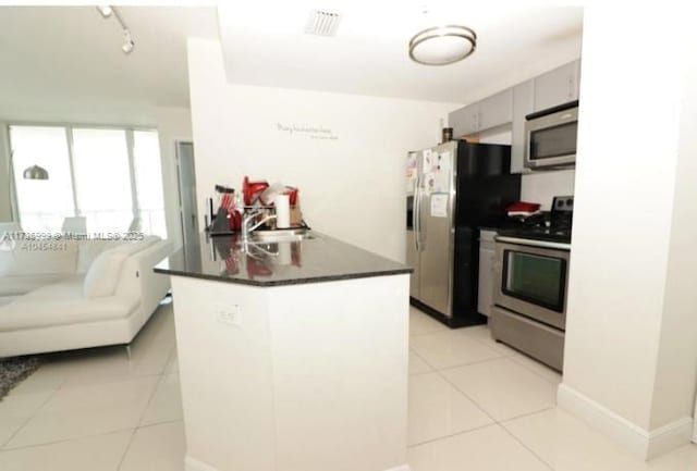 kitchen featuring rail lighting, appliances with stainless steel finishes, sink, and light tile patterned floors