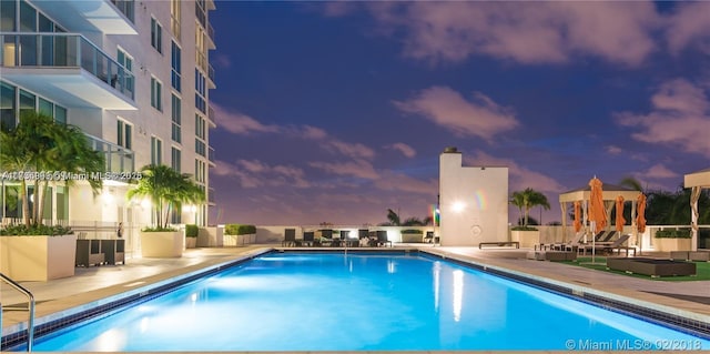 pool at dusk with a patio