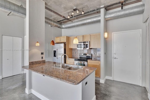 kitchen featuring light brown cabinetry, sink, tasteful backsplash, stainless steel appliances, and a high ceiling