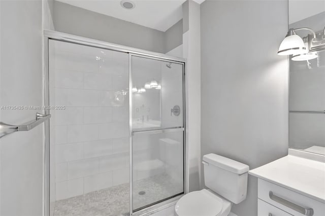 bathroom featuring walk in shower, vanity, and toilet