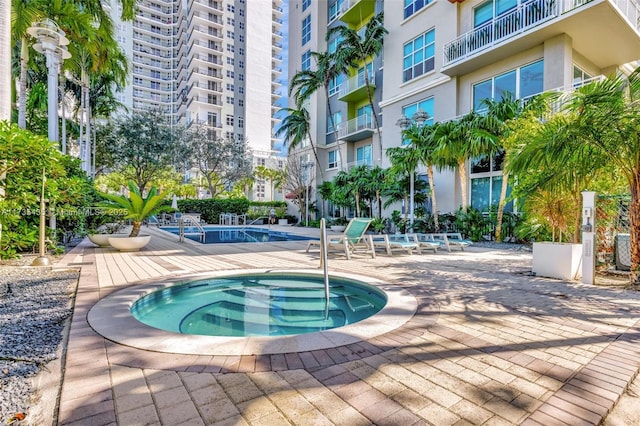 view of pool featuring a patio and a community hot tub