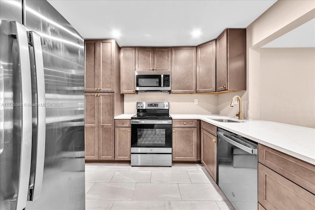 kitchen with sink, stainless steel appliances, and light tile patterned flooring